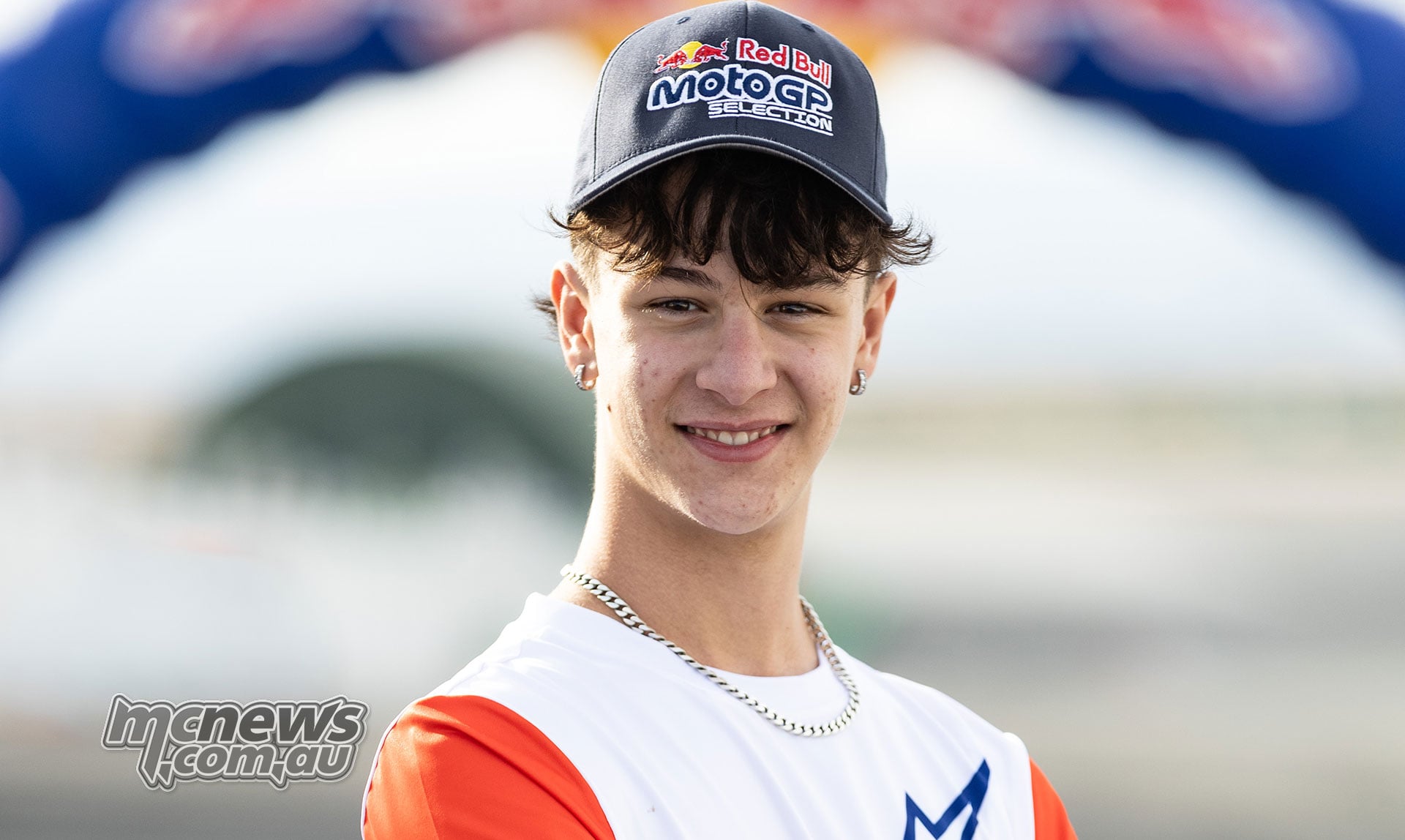 Italian rider Mathias Tamburini wearing a Red Bull MotoGP Selection cap and orange-sleeved Alpinestars shirt