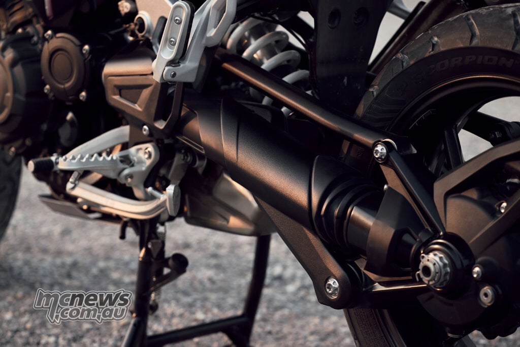 Close-up of the shaft-drive housing, Tri-Link swingarm, footpeg and centre stand on a 2027 Triumph Tiger 1200 GT Pro.