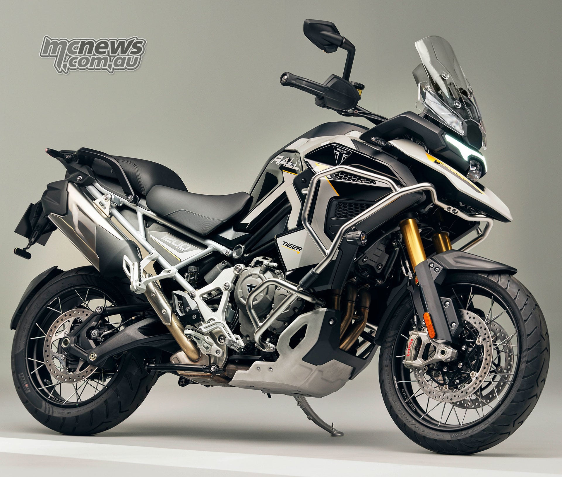 2027 Triumph Tiger 1200 Rally Explorer viewed from the front right with tall screen and protective crash bars