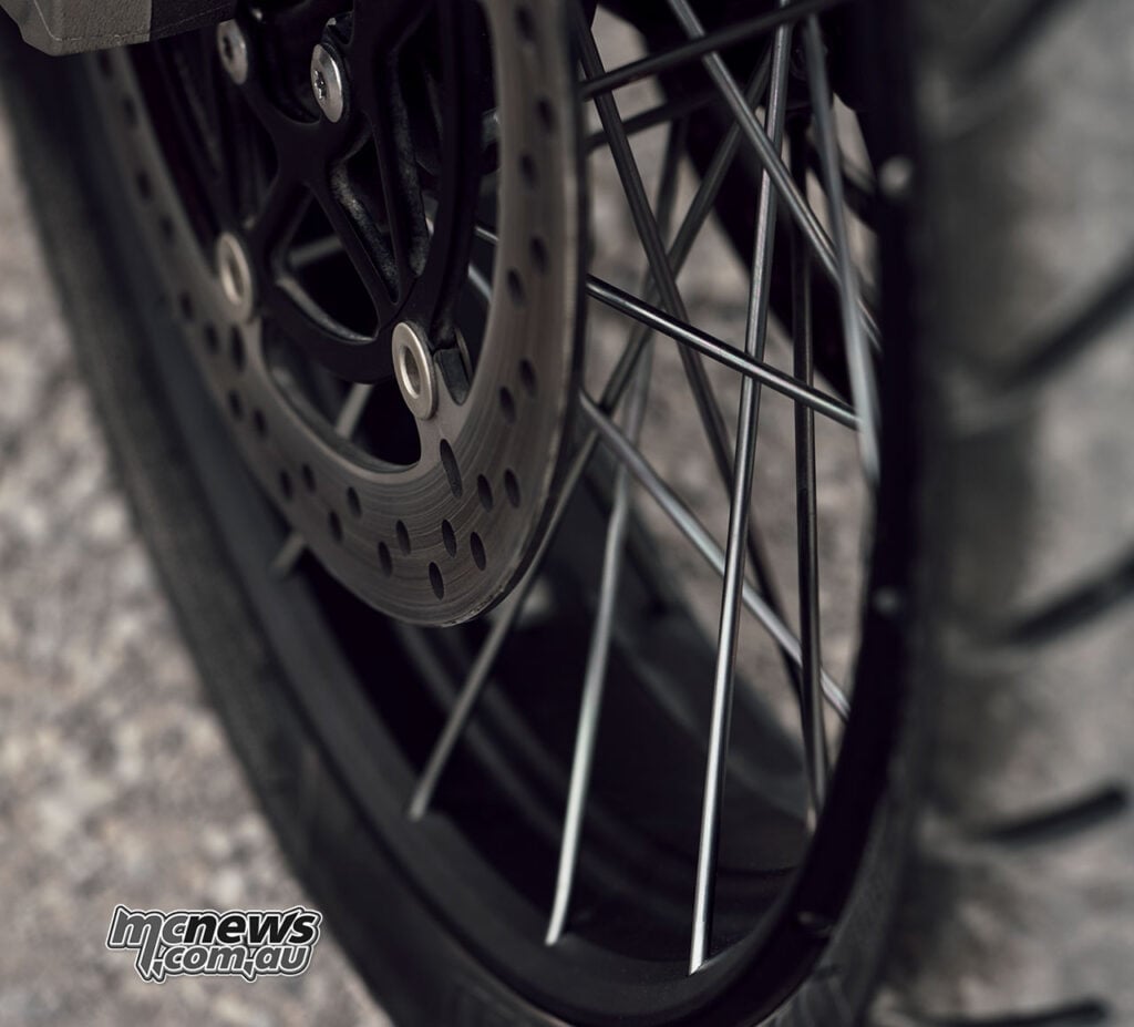Close-up of the black spoked wheel, rim and brake disc on a 2027 Triumph Tiger 1200 Rally Explorer.