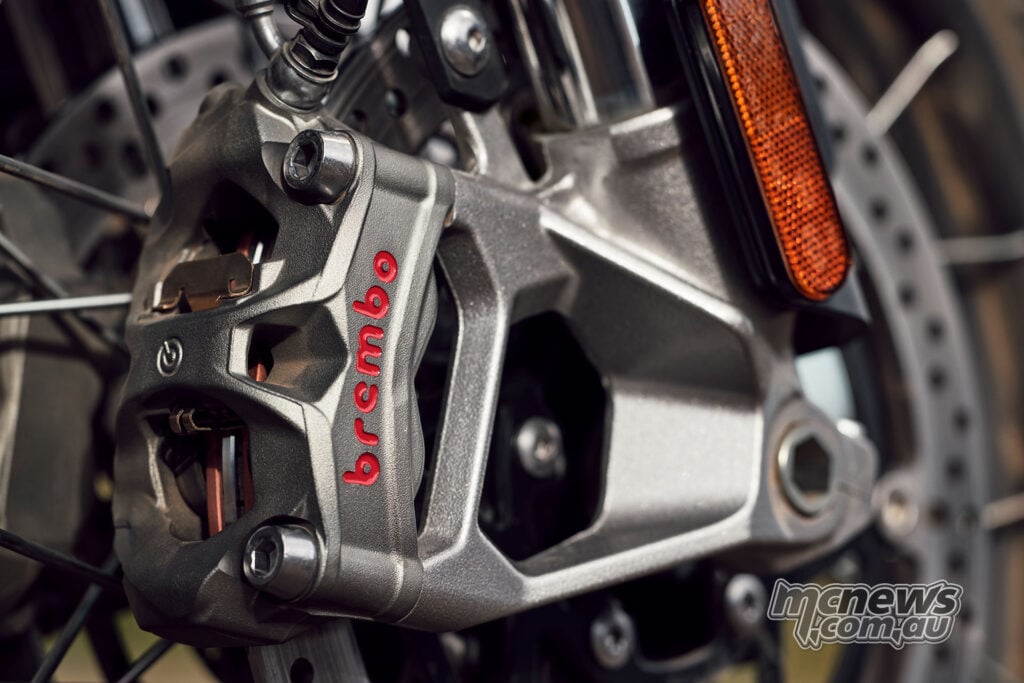 Close-up of a Brembo front brake caliper, disc, fork leg and reflector on a 2027 Triumph Tiger 1200 Rally Pro.