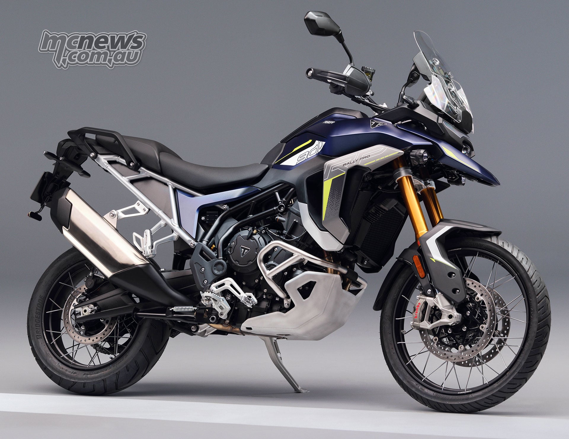 2027 Triumph Tiger 900 Rally Pro viewed from the front right with gold forks, spoked front wheel and engine protection