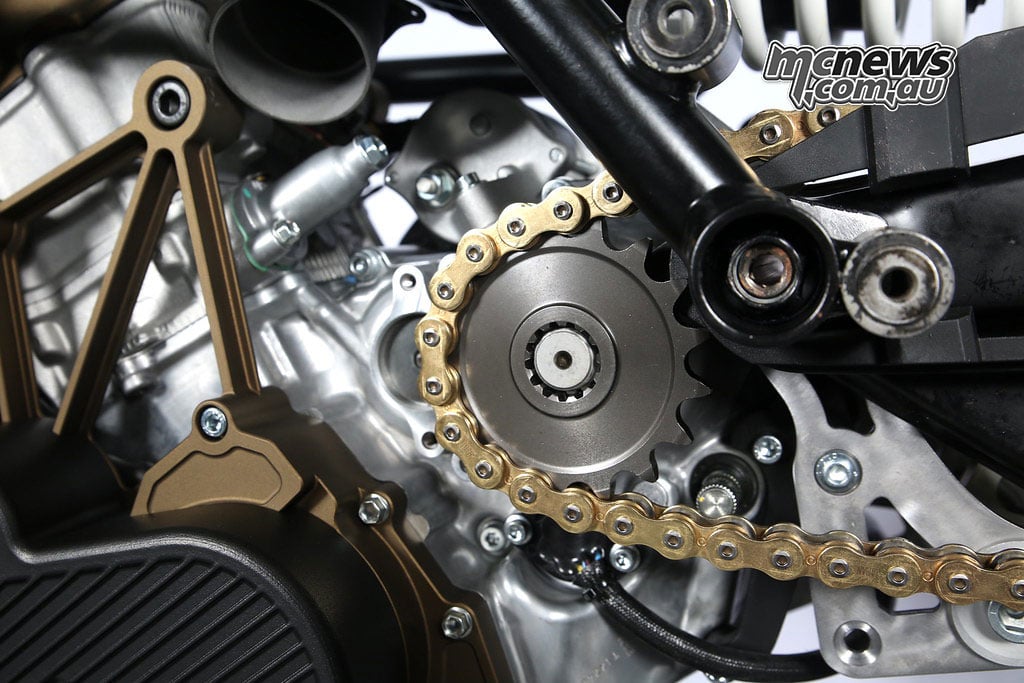 Front sprocket and gold drive chain beside the Mono RR swingarm pivot.