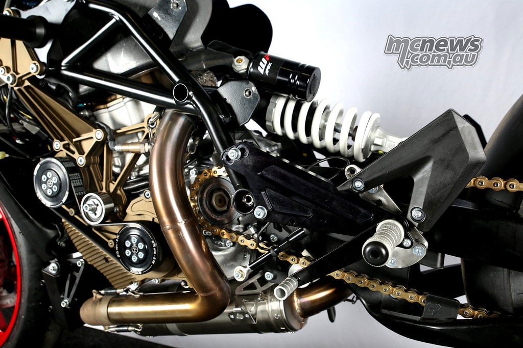 Curved exhaust header running past the Mono RR rear shock towards its low-mounted silencer.