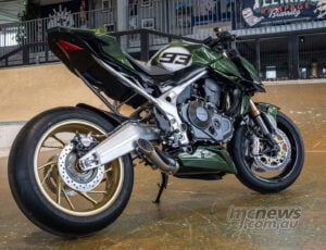 Rear three-quarter indoor view of Honda CB750 Hornet Mugen custom with gold wheel and green bodywork