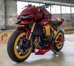 Low-angle view of Honda CB750 Hornet Concept 2077 custom indoors with red and gold bodywork