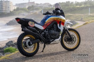 Rear angle of Honda XL750 Transalp Dakar Tribute custom showing off-road tyres, twin pipes and rally styling