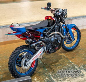 Rear three-quarter view of Honda XL750 Transalp Ruth custom with blue wheels and twin exhausts