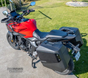 The 825 mm rider’s seat is easy to flat-foot at 178 cm, although the taller pillion pad demands a higher leg swing when climbing aboard. Elevated view of the Honda CB1000GT stepped seats, fuel tank, cockpit and integrated panniers.