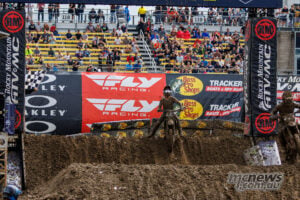 Haiden Deegan rides beneath the finish gantry and chequered flag to win the muddy opening 450SMX moto at Columbus.