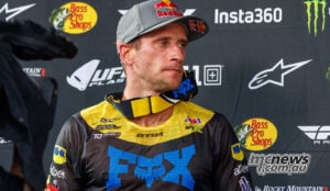 Ken Roczen in Suzuki race gear and a Red Bull cap, with his goggles around his neck after racing.