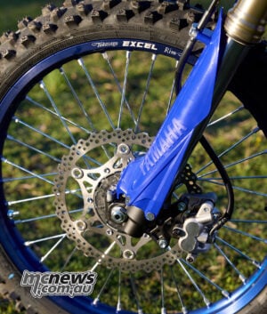 The 48 mm KYB Speed Sensitive System fork retains 300 mm of travel and tool-free compression adjustment, while the front brake continues with a 270 mm disc and Nissin caliper. 2027 Yamaha WR450F KYB front fork, 270 mm brake disc and Nissin front caliper
