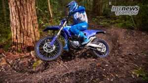 From the original WR400F onwards, the formula has been to take serious competition-derived four-stroke performance and make it work across real-world enduro terrain. 2027 Yamaha WR450F being ridden through a technical forest enduro section