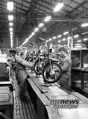 Motorcycle assembly at Mandello around 1970. The factory has changed enormously, but Guzzi’s connection to the town endures. Black-and-white photograph of workers assembling a row of motorcycles in the Mandello factory around 1970.