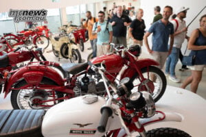 The new museum gives Guzzi owners and enthusiasts plenty to linger over, from humble runabouts to the marque’s most celebrated machines. Visitors walk among red, cream and white historic Moto Guzzi motorcycles in the new museum.