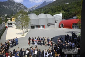 The ribbon is cut on Moto Guzzi’s redeveloped factory and museum on September 2, 2026, ahead of the four-day GMG celebration. Guests gather around a red ribbon at the opening of Moto Guzzi’s new museum beneath the Mandello mountains.